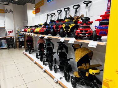 Lviv, Ukrayna - 16 Şubat 2025: Renkli çocuklar oyuncak arabalar ve bebek arabaları bir mağazada düzgünce sergilenmiş raflar