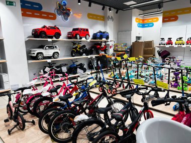 Lviv, Ukrayna - 16 Şubat 2025: Bir mağazanın vitrininde çeşitli çocuk bisikletleri, scooterları ve oyuncak araçlar