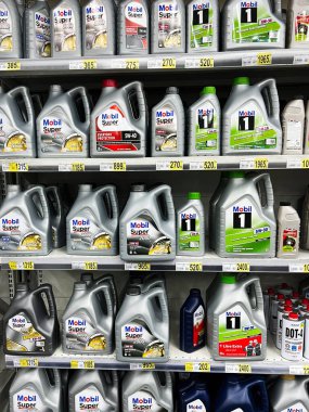 Lviv, Ukrayna - 16 Şubat 2025: Çeşitli marka ve özelliklere sahip süpermarket raflarında motor yağı mobil kapları