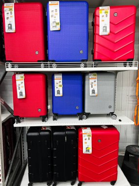 Lviv, Ukrayna - 16 Şubat 2025: Bir mağaza rafında çeşitli renklerde uzun süreli seyahat valizlerinin seçimi