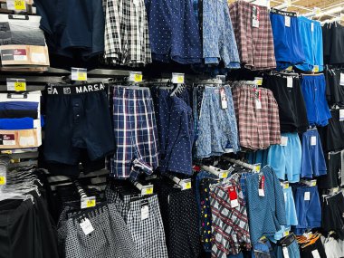 Lviv, Ukrayna - 16 Şubat 2025: Erkek giyim reyonunda askılar üzerinde renkli boksörler ve iç çamaşırları düzenlendi.