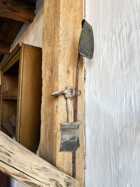 Eski el aletleri desenli ahşap kirişlere asılmış, klasik, kırsal tarzda sergileniyor..