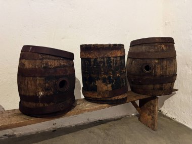 Üç kırsal ahşap fıçı eski bir atmosferde ahşap bir bankta dizilmiş.