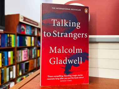 Lviv, Ukraine - February 20, 2025: Cover of the book Talking to Strangers by Malcolm Gladwell in a library. clipart