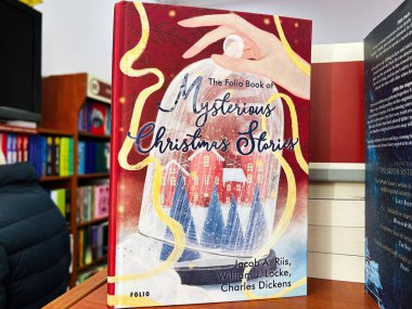 Lviv, Ukrayna - 20 Şubat 2025: Jacob Riis, William Locke ve Charles Dickens 'ın gizemli Noel hikayelerinin sayfası. Kar yağışı ve tatil temasının yer aldığı karmaşık bir kitap kapağı