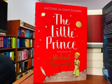Lviv, Ukrayna - 20 Şubat 2025: Antoine de Saint-Exupery 'nin Küçük Prens kitabının parlak kırmızı kapağı, ahşap bir kütüphane rafında sergilendi..
