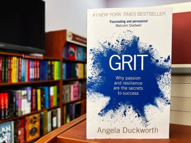 Lviv, Ukrayna - 20 Şubat 2025: Angela Duckworth 'un Grit' in ön kapağı arka planda raflarla birlikte bir kütüphane ortamında gösteriliyor