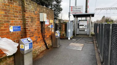 Londra, İngiltere - 21 Şubat 2025: Enfield, Londra, İngiltere 'de Oyster okuyucuları ve tabelalarıyla banliyö tren istasyonu girişi