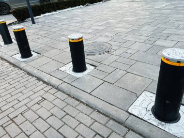 Siyah geri çekilebilir kalınlar ve şehir kaldırım tasarımında bir rögar kapağı.