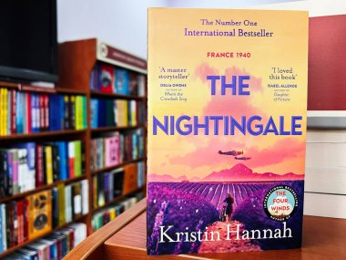 Lviv, Ukrayna - 20 Şubat 2025: Kristin Hannah 'nın Nightingale kitabı arka planda canlı raflar bulunan bir kitapçıda sergilendi