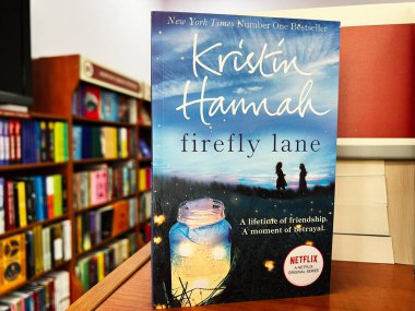 Lviv, Ukrayna - 20 Şubat 2025: Firefly Lane kitabı Kristin Hannah tarafından bir kitapçıda çevrili diğer kitaplıklar.