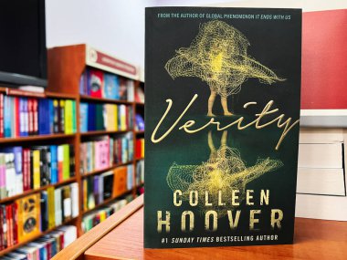 Lviv, Ukrayna - 20 Şubat 2025: Colleen Hoover 'ın Verity adlı kitabının yakın çekimi kütüphanedeki ahşap bir rafta sergilendi
