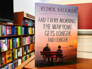 Lviv, Ukrayna - 20 Şubat 2025: ve her sabah evin yolu daha da uzuyor. Fredrik Backman. Renkli kapağını ve başlığını kütüphane kitaplığında gösteren bir kitap.