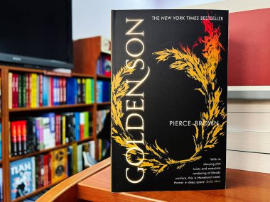 Lviv, Ukrayna - 20 Şubat 2025: Pierce Brown 'ın Altın Oğul romanı, canlı bir kitaplık arka planına dayandırıldı
