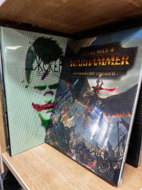 Lviv, Ukraine - February 20, 2025: Books include Joker by Andrea Corsini and Richard Albelda, Total War: Warhammer art book clipart