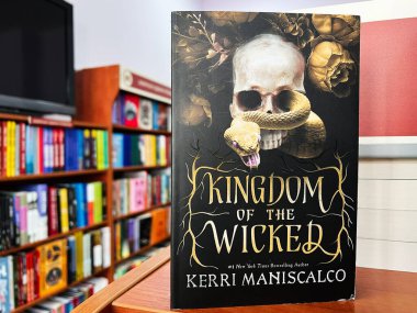 Lviv, Ukraine - February 20, 2025: Illustrated cover featuring a skull and snake, Kingdom of the Wicked by Kerri Maniscalco clipart