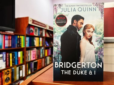 Lviv, Ukraine - February 20, 2025: The book The Duke & I by Julia Quinn displayed on a shelf in a library. clipart