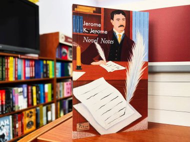 Lviv, Ukrayna - 20 Şubat 2025: Jerome K. Jerome 'un roman kapağı iyi aydınlatılmış bir kütüphanede kitaplarla çevrili.