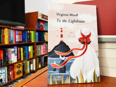 Lviv, Ukraine - February 20, 2025: Decorative cover of Virginia Woolf's novel To the Lighthouse in a library scene. clipart