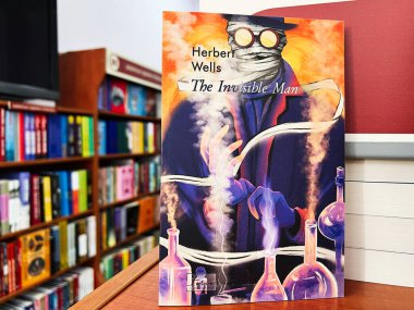 Lviv, Ukrayna - 20 Şubat 2025: Herbert Wells tarafından kapatılan görünmez adam kitapçıda renkli raflarla çevrili.