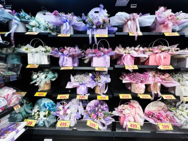 Kyiv, Ukrayna - 26 Şubat 2025: Dekoratif kutular ve ambalajlarda renkli çiçek aranjmanlarının yer aldığı canlı raflar.