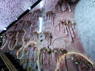 Kyiv, Ukrayna - 26 Şubat 2025: Pembe bir duvarda sanatsal ve sofistike bir ortam sunan dekoratif çiçek düzenlemeleri