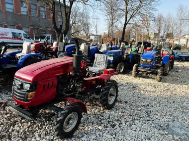 Kyiv, Ukrayna - 26 Şubat 2025: Parlak güneş ışığı altında sergilenmeye hazır çeşitli traktörler.