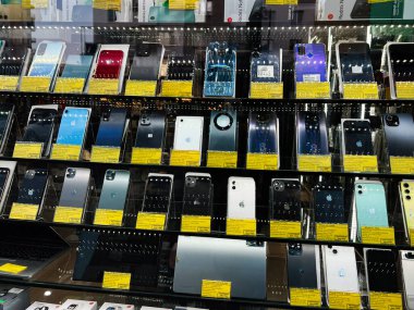 Kyiv, Ukrayna - 27 Şubat 2025: Fiyat ve özelleştirme etiketleri bulunan bir mağaza dolabında birden fazla akıllı telefon seçimi