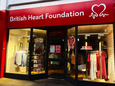 Londra, İngiltere - 02 Mart 2025: Kıyafet sergisi ve tanıtım posterleri olan bir hayır kurumunun mağazası