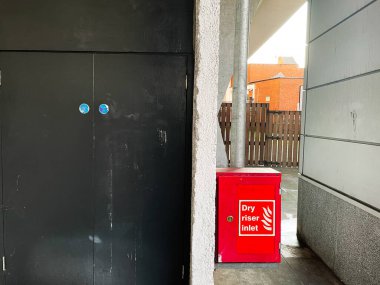 Londra, İngiltere - 02 Mart 2025: Kentsel alanda yangın güvenlik ekipmanları ve yapısal açık hava yakınında kırmızı basamaklı dolap