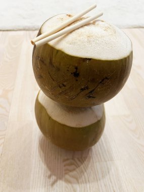 Bir çift açık hindistan cevizi, ahşap bir yüzeye yerleştirilmiş.