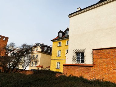 Klasik Varşova tuğlası ve taştan binalar. Ağaçları ve canlı kentsel yapıları var..