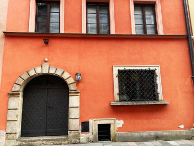 Polonya, Varşova 'da turuncu bir binanın kapısı ve parmaklıklı penceresi.