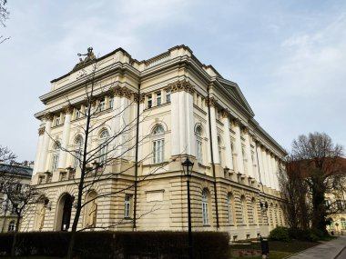 Polonya 'nın Varşova şehrinde mavi gökyüzüne karşı aşağıdan görülen zarif tarihi üniversite yapısı