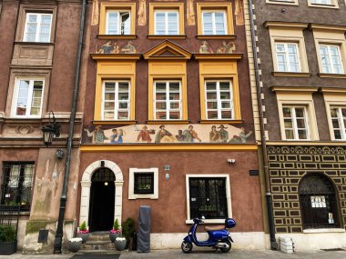 Varşova, Polonya - 09 Mart 2025: Varşova 'da boyalı duvar resmi ve mavi scooter' ın yer aldığı büyüleyici eski bina cephesi. Szeroki Dunaj Caddesi.