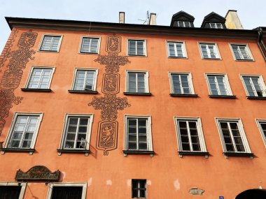 Varşova, Polonya - 09 Mart 2025: Varşova, Polonya 'da detaylı dekoratif tasarım ve pencerelere sahip turuncu bina