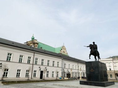 Varşova, Polonya - 09 Mart 2025: Atlı Jozef Poniatowski heykeli Polonya 'nın Varşova kentinde bulutlu bir gökyüzü altında tarihi binaların yakınında