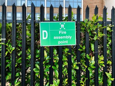 Doğa ve binalarla çevrili, rayların üzerinde yeşil bir yangın noktası işareti..