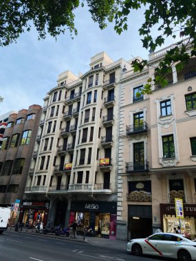 Madrid, İspanya - 22 Ağustos 2024: Madrid 'de hareketli bir şehir caddesinde klasik mimari cephesi.