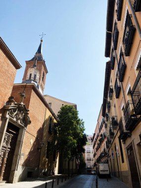 Madrid, İspanya - 22 Ağustos 2024: Madrid 'de geleneksel İspanyol mimarisi ve San Nicolas Kilisesi' nin yer aldığı sessiz sokak manzarası.