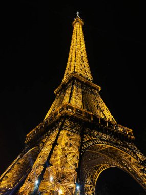 Paris, Fransa - 30 Nisan 2024: Eyfel Kulesi, Pariss ikonik yapısını gözler önüne sererek gece parlıyor.