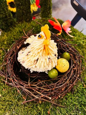 Rustic decoration featuring a crafted chicken figure, twigs nest, and painted green eggs clipart