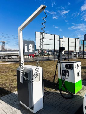 Kyiv, Ukrayna - 10 Mart 2025: Modern elektrikli araç şarj istasyonu kablo ve açık hava tabelalı