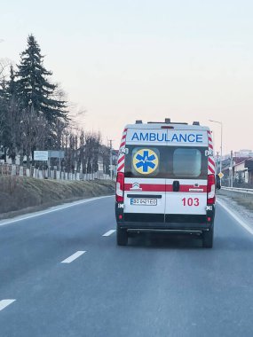 Kyiv, Ukrayna - 10 Mart 2025: Kırsal bir yolda ambulansın sürüşü aciliyet ve hizmet hissi yaratıyor