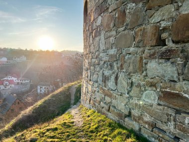Gün batımında manzaralı bir köy manzaralı taş bir duvar ve çimen yolu.