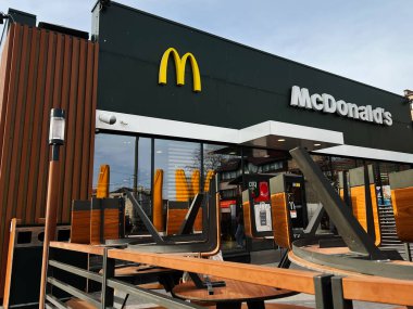 Kyiv, Ukrayna - 12 Mart 2025: Kaldırılmış sandalyeler ve modern mimari ile McDonald 's restoranında ahşap dekor terası.