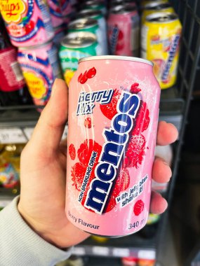 Kyiv, Ukrayna - 12 Mart 2025: Bir mağazada renkli bir Mentos konserve meyve suyu tutan bir el.