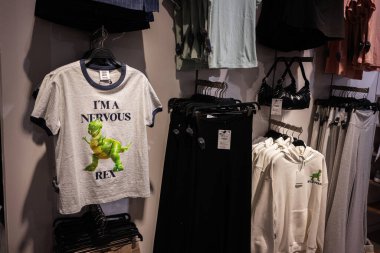 Lviv, Ukrayna - 13 Mart 2025: Eğlenceli Oyuncak Hikayesi dinozor grafikli kısa kollu gömlek ve ben Gergin Rex metin perakende giyim mağazasında asılı.