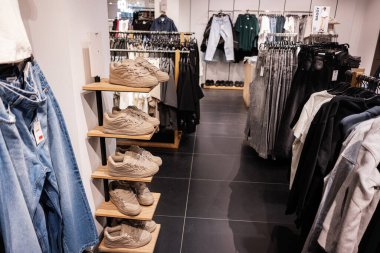 Lviv, Ukrayna - 13 Mart 2025: Spor ayakkabıları, kot pantolonlar ve raflarda günlük giysiler sergilenen moda perakende mağazası.