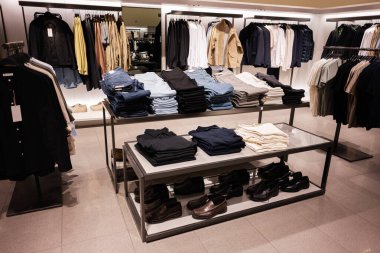 Lviv, Ukrayna - 13 Mart 2025: Şık bir perakende mağazasında erkek giyimi ve ayakkabılarının düzenli gösterimi.